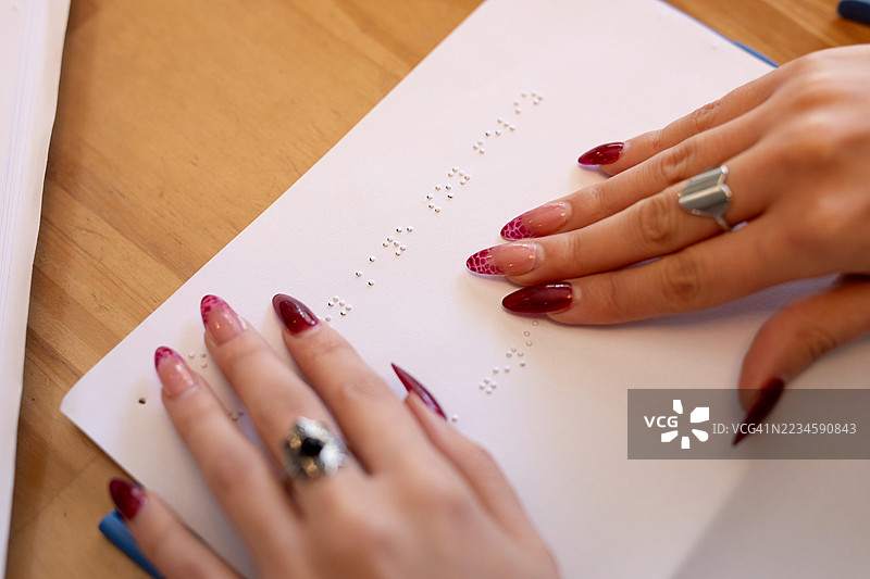 盲人女性的手在纸上书写盲文的特写镜头图片素材