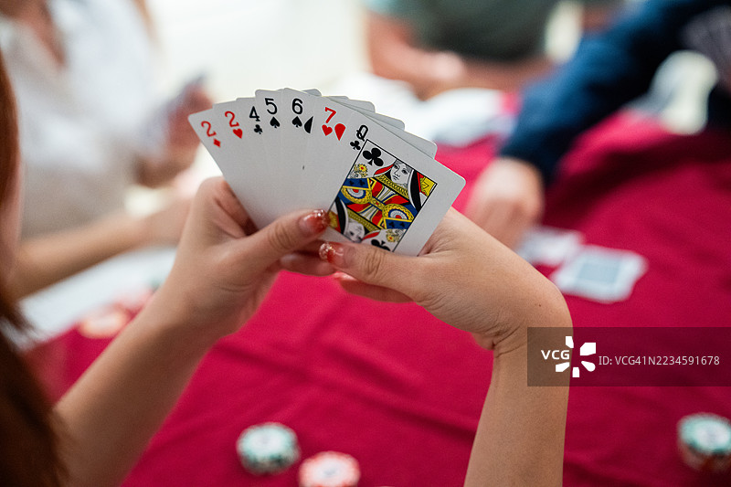 手握扑克牌进行游戏图片素材