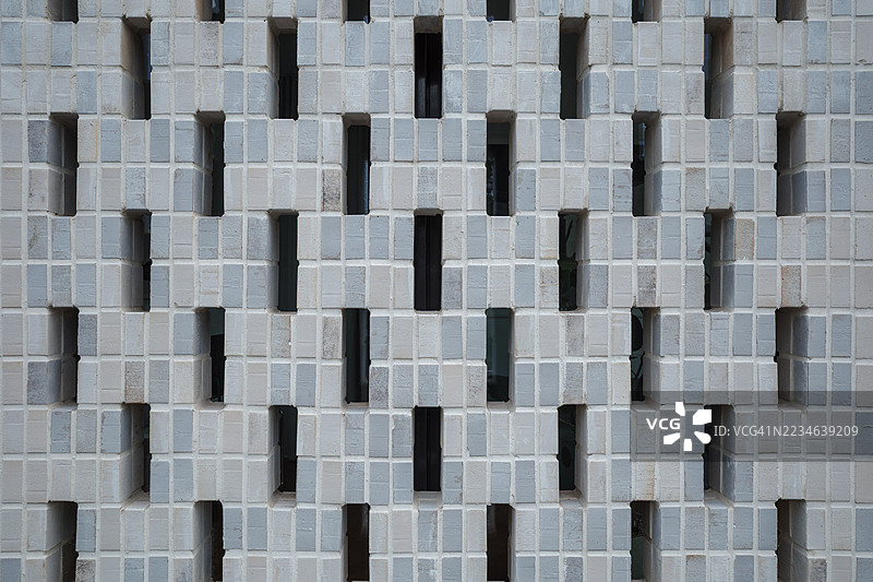 现代穿孔通风砖屏风墙的对称图案。图片素材