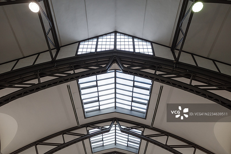 历史大厅中带天窗的对称工业桁架天花板视图。图片素材