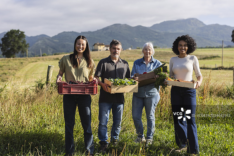 农民手持新鲜采摘的蔬菜和葡萄篮子图片素材