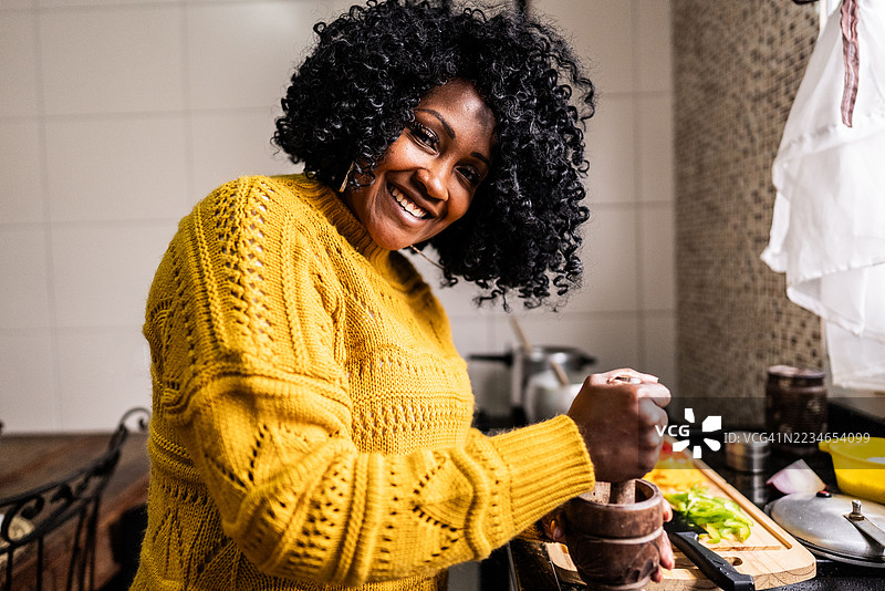 一位成熟的女性在家里的厨房里烹饪肖像图片素材