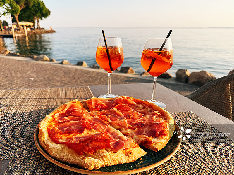 在意大利维罗纳省加尔达湖畔的餐厅里，供应着意大利火腿披萨和Spritz鸡尾酒。图片素材