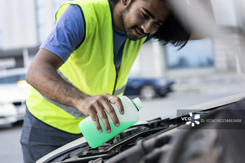 年轻男子正在添加冷却液图片素材