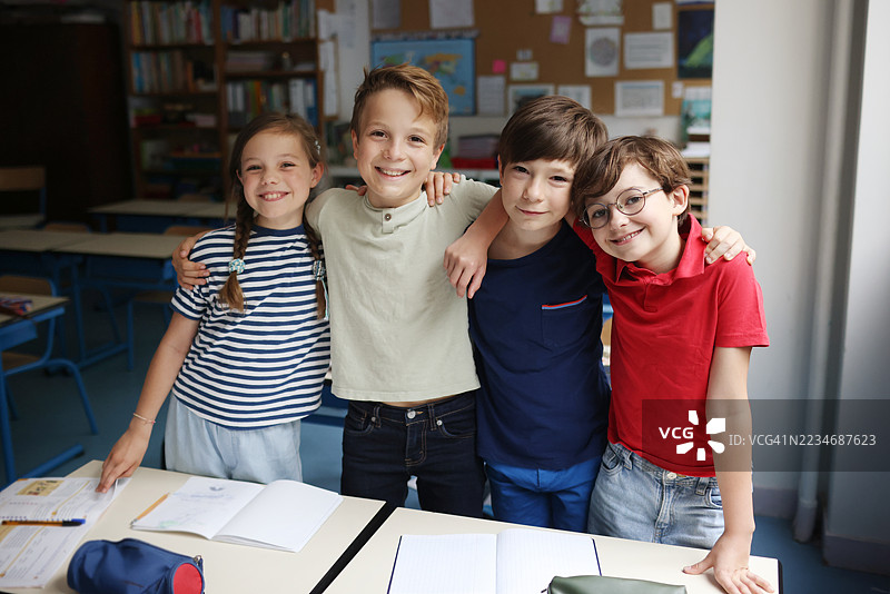 四个十岁的孩子在教室里一起摆姿势图片素材