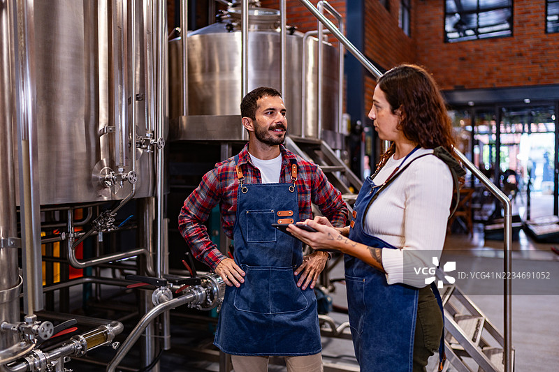同事们在酿酒厂交谈并检查酒桶图片素材