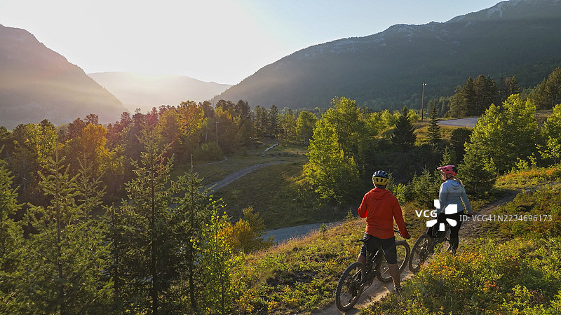 黎明时分，山地自行车骑行者在小径上的鸟瞰图图片素材
