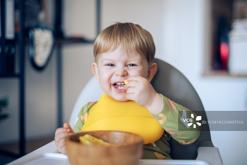 可爱的幼儿男孩独自吃东西。图片素材
