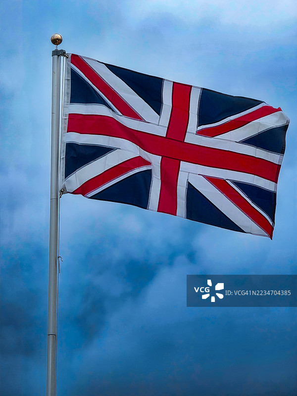暴风雨天气下的英国国旗在旗杆上飘扬图片素材