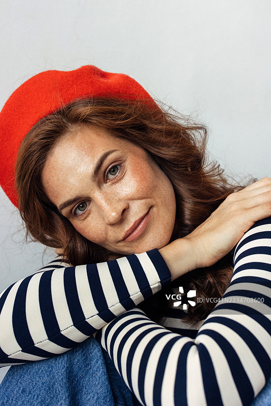 一位穿着条纹上衣和红色贝雷帽的快乐女性肖像图片素材
