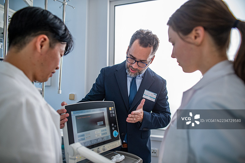 医院主任向医生团队展示新医疗技术。图片素材