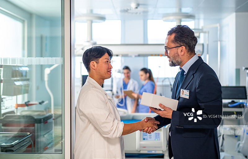 药品销售代表向医生介绍新药，握手。图片素材