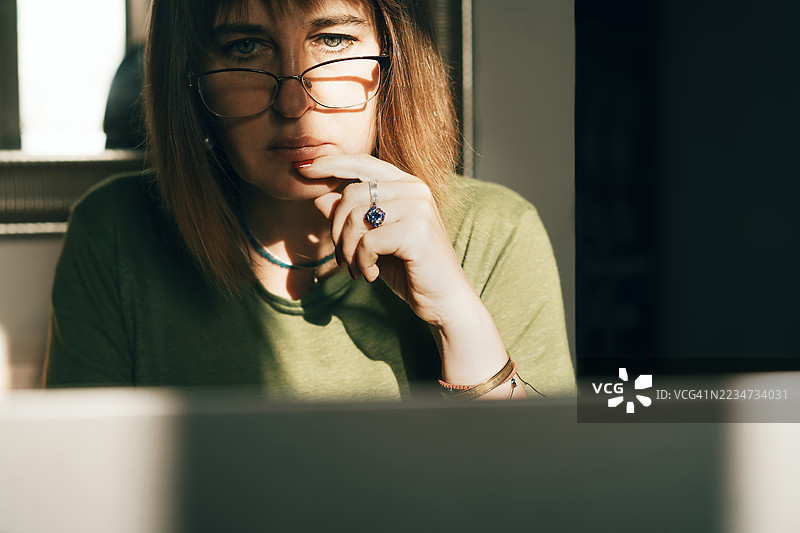 专注的女性在阳光照耀下居家工作图片素材