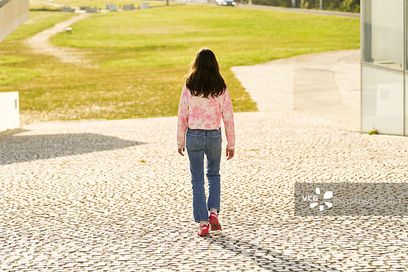 现代城市公园里走开的少女图片素材