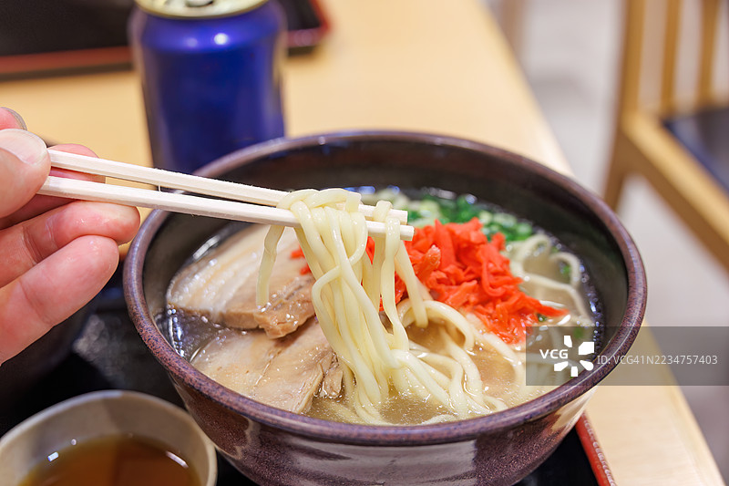 午夜时分抵达那霸机场。在那霸机场自助餐厅享用美味的冲绳荞麦面。冲绳特产海藻海葡萄作为开胃菜，搭配冲绳啤酒。日本冲绳那霸市那霸机场 - 2025年6月30日图片素材