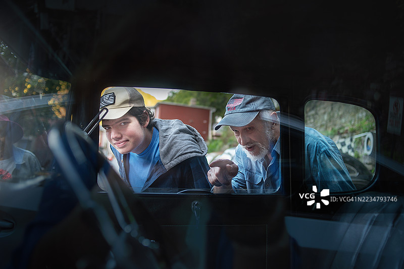 70岁的祖父与患有自闭症的十几岁孙子在宾夕法尼亚州吉姆·索普的一辆老式汽车车窗旁。图片素材