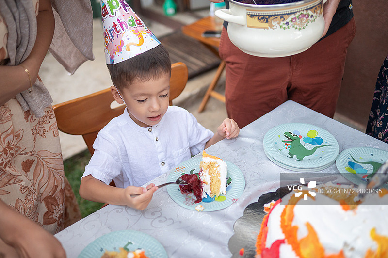 小男孩在生日派对上兴奋地吃蛋糕图片素材