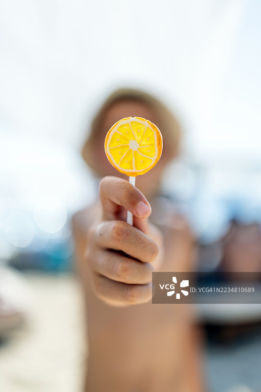 户外阳光明媚下的柠檬形棒棒糖特写图片素材