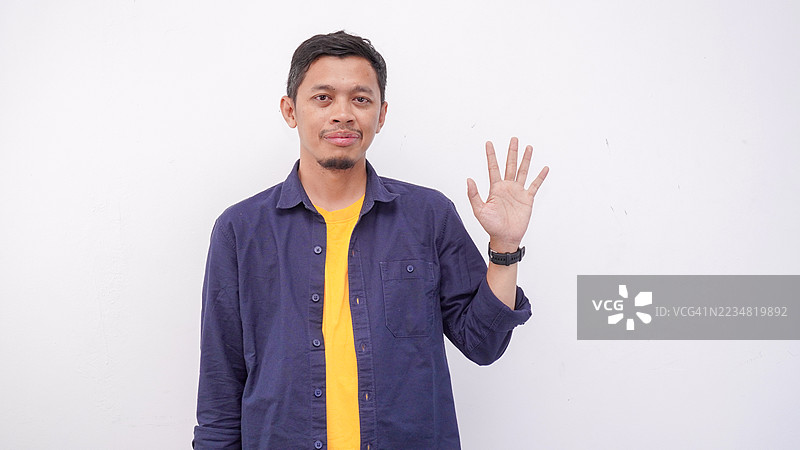 亚洲男子在孤立背景下用手指指向上方并展示数字图片素材