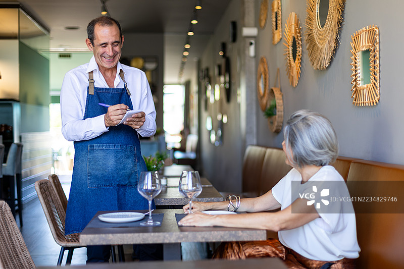 高级服务员在餐厅为顾客点餐图片素材
