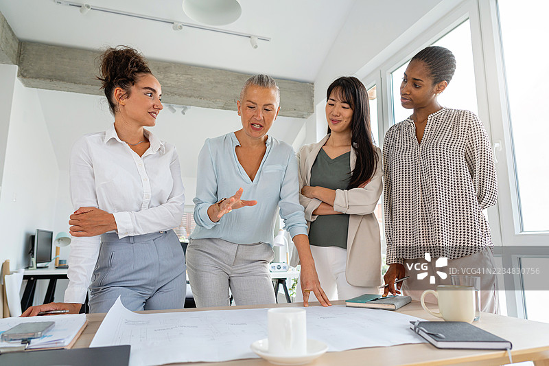 多元化的女性商业人士在现代办公室环境中合作项目图片素材