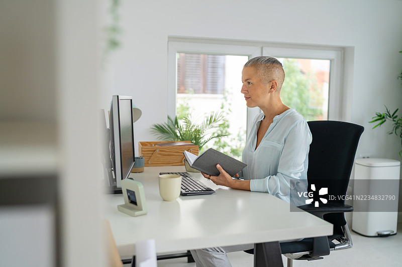 现代办公室中，商界女性正在审阅材料，设计明亮而清新。图片素材