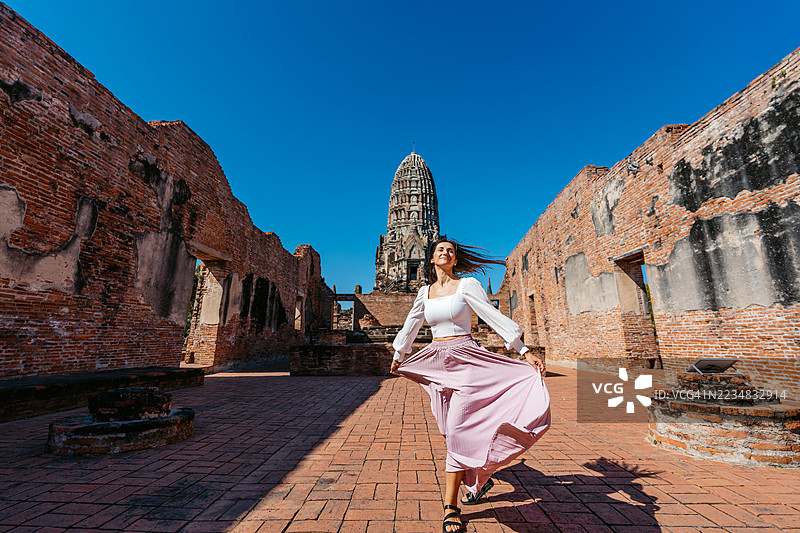 年轻女性在泰国大城历史公园的拉差布拉那寺旋转图片素材
