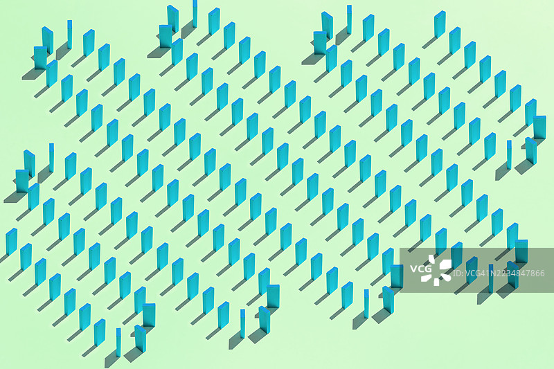 多米诺骨牌在绿色背景上形成连锁反应倒下图片素材