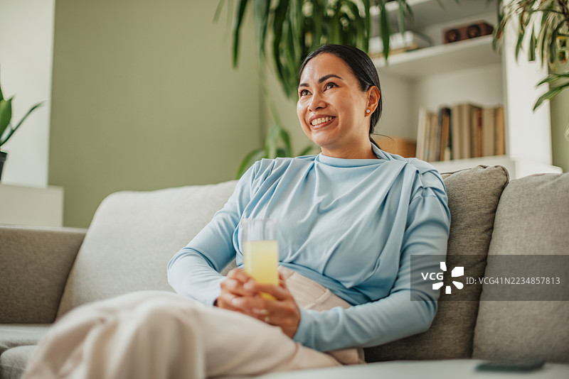 放松的亚洲女性在阳光和植物环绕下享受宁静的周末时光图片素材