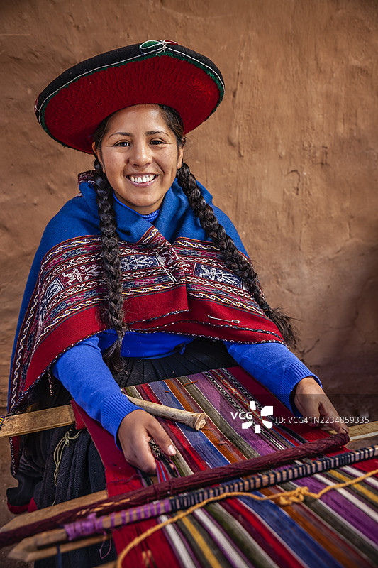 年轻的秘鲁女性在神圣谷的钦切罗编织图片素材