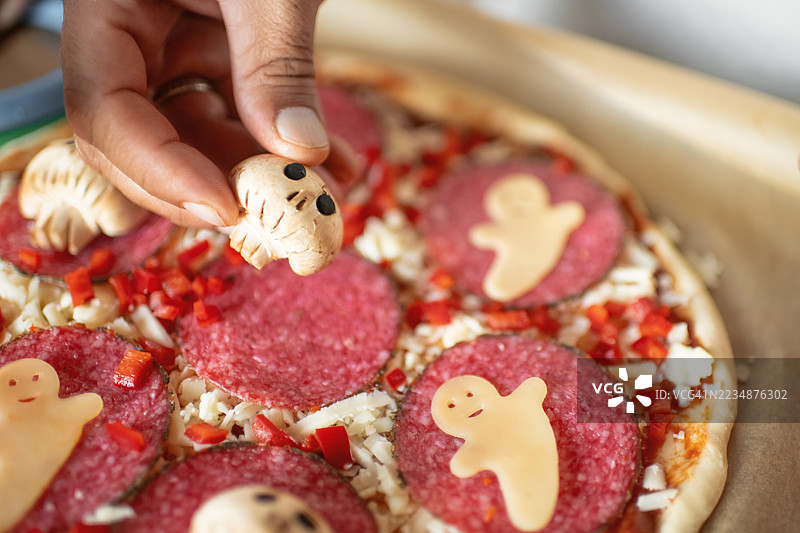 男人在厨房为万圣节制作披萨图片素材