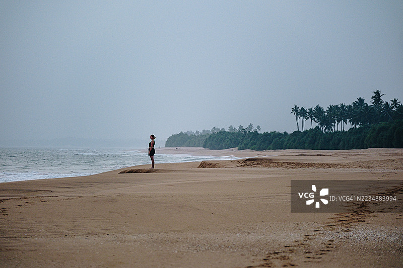 年轻女性在日落时享受海滩时光图片素材