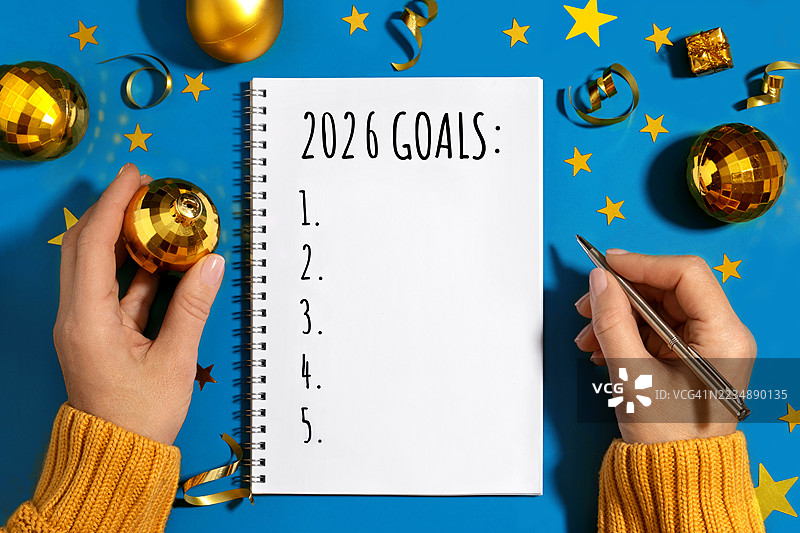 蓝色的圣诞快乐和新年快乐邀请卡，新的目标概念。在冬季假期庆祝活动中书写2026年的新年目标。图片素材