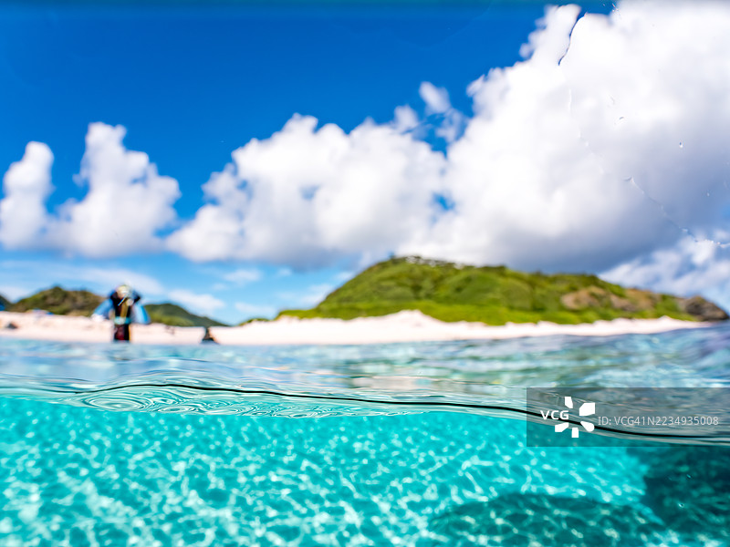 可以看到阳伞、船只,甚至是独特于冲绳的双体船Sabani。拍摄了美丽白沙滩的一半。还有一群热带鱼。美丽的珊瑚礁和游泳的人们。外岛、座间味岛、慶良間群岛。图片素材