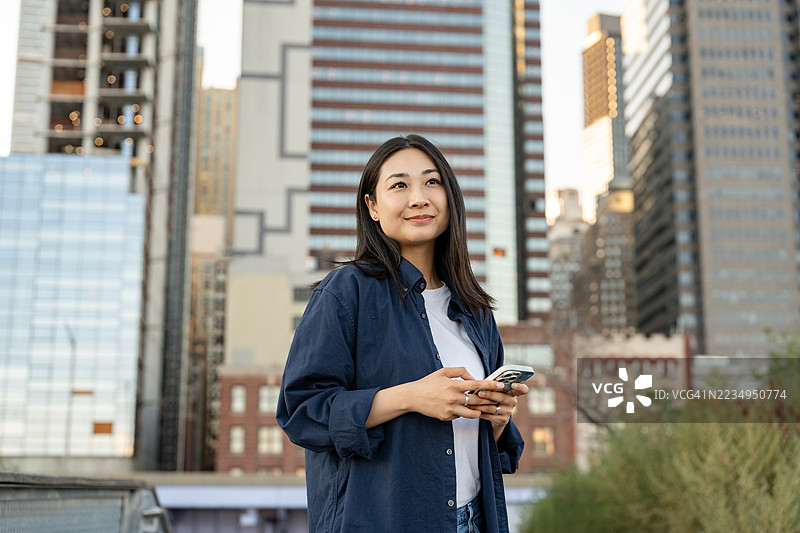 亚洲女性在城市中使用手机图片素材