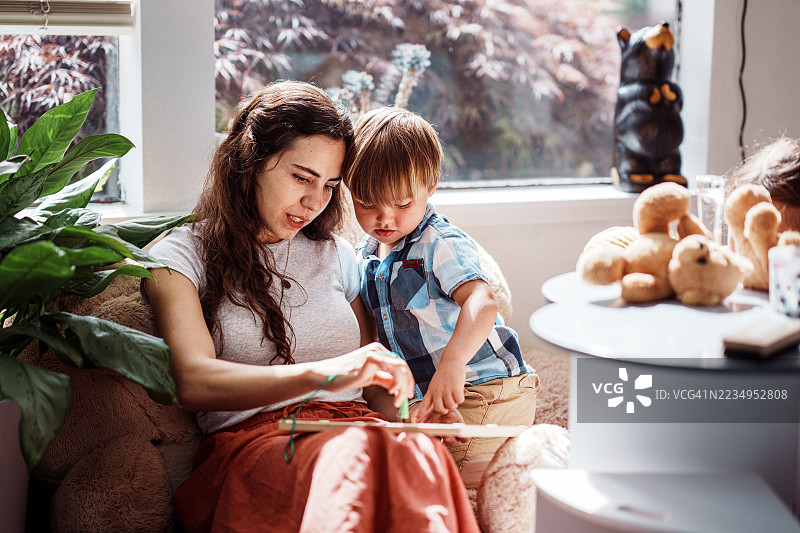 母亲和儿子在银行候客区玩耍图片素材