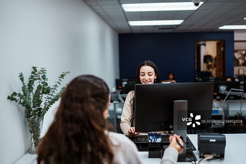 女银行出纳员正在协助客户图片素材