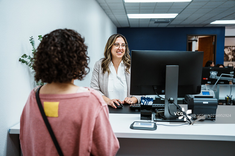 银行柜台的工作人员在协助客户图片素材