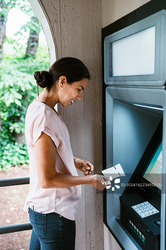 墨西哥女性在信用合作社使用自动取款机图片素材