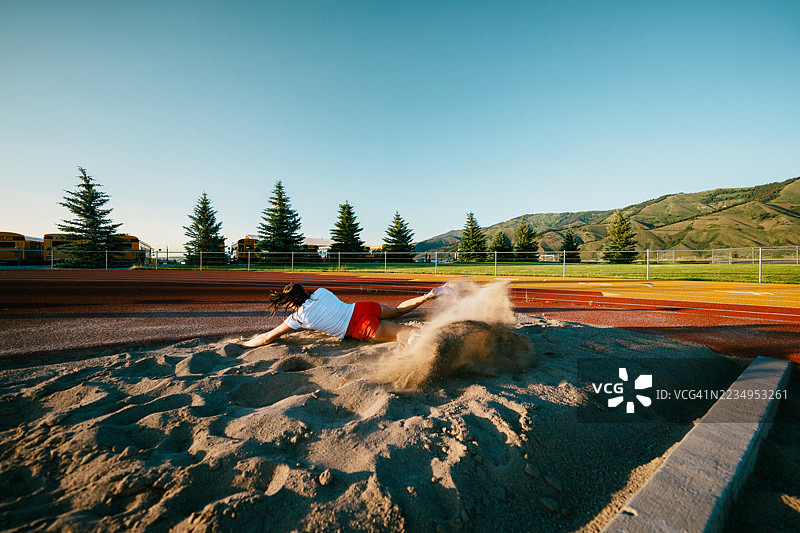 女性田径运动员落入沙坑图片素材