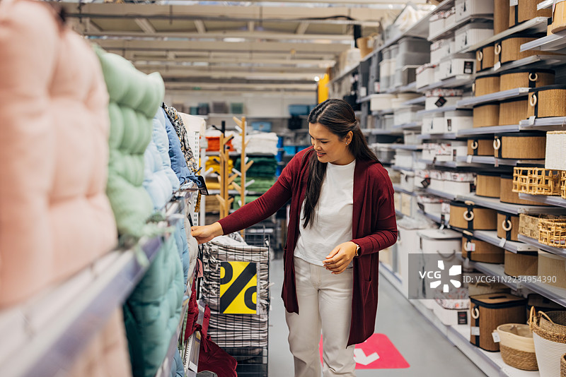 亚洲女性正在浏览为户外椅子设计的柔软坐垫图片素材