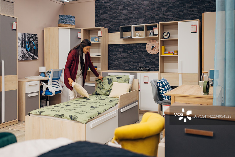 亚洲女性在现代家具店探索卧室布置图片素材
