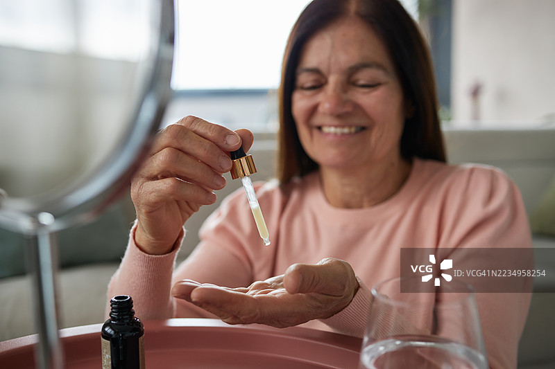 一位年长的女性正在呵护她的肌肤图片素材