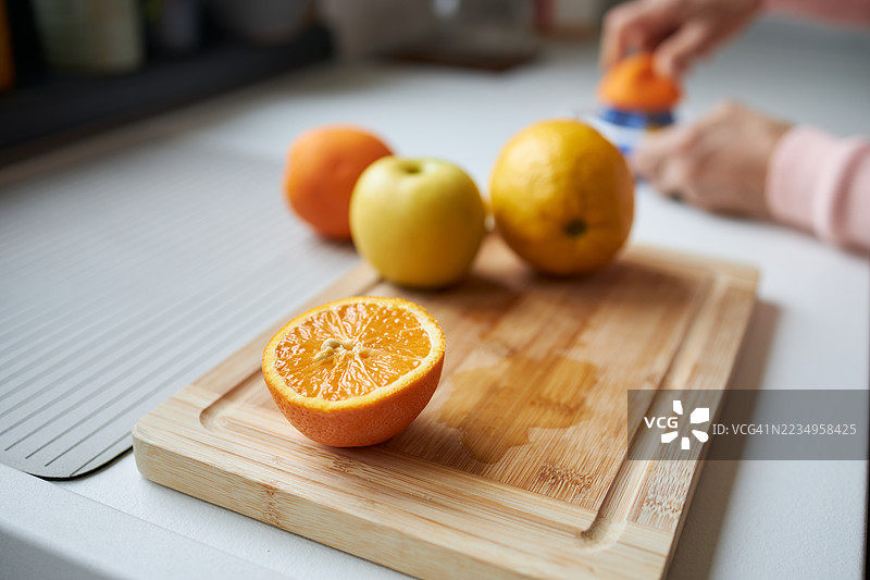女子双手近距离制作鲜榨果汁的特写图片素材