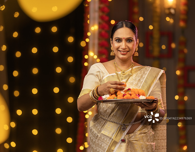 在丰收节期间，家中与鲜花相伴的快乐女性图片素材