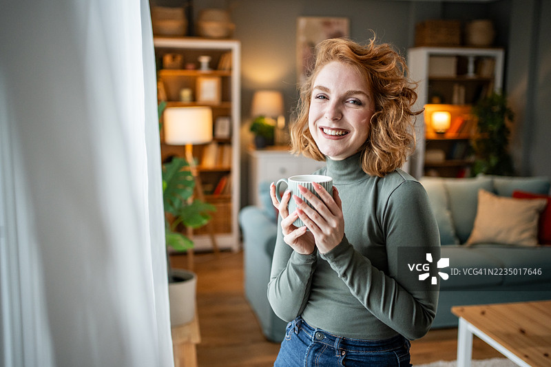 年轻女性在家中享受温暖饮品图片素材