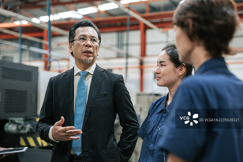 不满的亚洲高管在生产车间对工厂团队进行简报图片素材