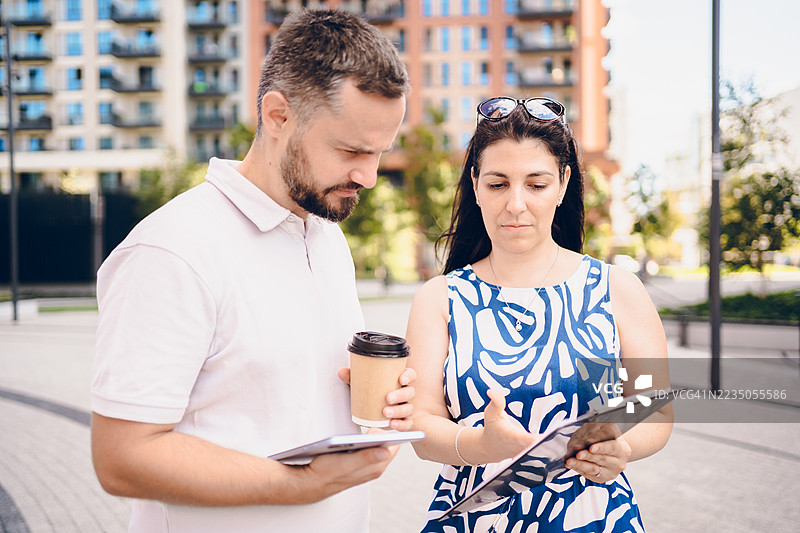 两位商务同事在户外散步时交谈图片素材