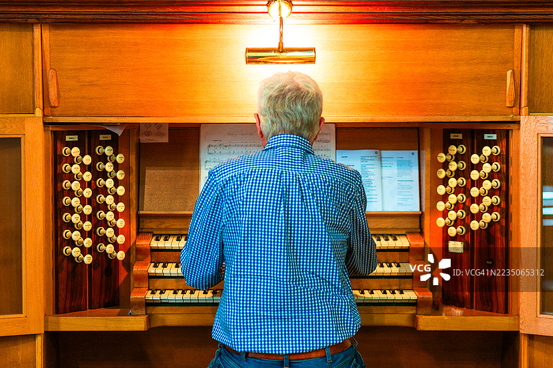 年长男性管风琴师在教堂演奏管风琴图片素材