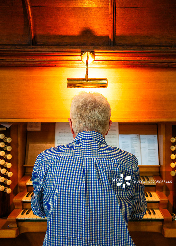 年长男性管风琴师在教堂演奏管风琴图片素材
